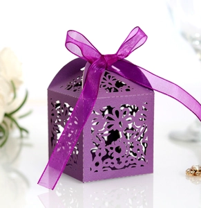 Detail of purple laser-cut flower patterns and organza ribbon bow on a gift box