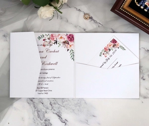 Macro detail of pocket fold wedding invitation set with floral prints on marble