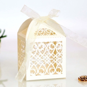 Close-up of laser-cut floral pattern and ivory ribbon on a wedding favor gift box