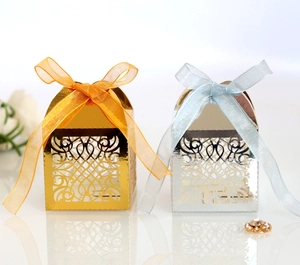 Detailed laser cut gold and silver wedding favor boxes with elegant silk ribbons