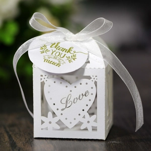 Detail of white laser-cut hollow heart candy box with Love motif and ribbon bow