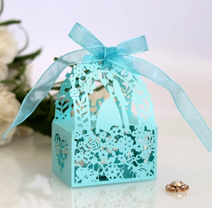 Detail showing the laser-cut sky blue wedding favor box with a delicate ribbon bow