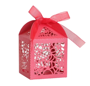 Laser-cut red paper gift box with intricate hollow vine patterns and a ribbon bow