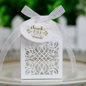 Detail of white laser-cut gift box with thank you tag and translucent white ribbon bow
