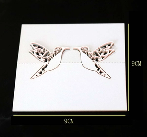 Detail of laser-cut 3D white hummingbird table card with 9cm size measurement