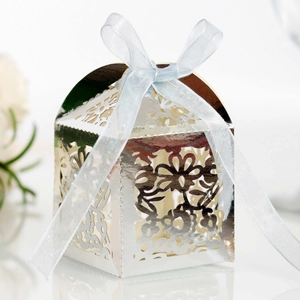 Detail of silver laser-cut wedding favor box with intricate floral hollow pattern