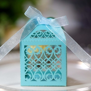 Detail of laser-cut floral pattern on blue wedding candy box with silk bow decoration