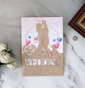 Detail of gold glitter cake topper featuring a couple silhouette and wedding lettering