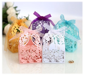 Laser-cut wedding favor boxes with ribbon bow and floral silhouettes in multiple colors