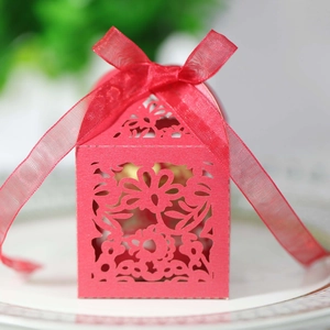 Detailed laser-cut heart pattern on a red gift box with a delicate ribbon bow
