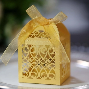 Detailed laser-cut European pattern on golden candy box with a silk ribbon bow