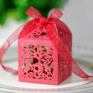 Detail of red laser-cut hollow gift box with elegant floral patterns and ribbon bow
