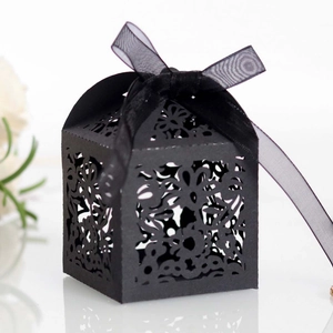Detail view of black laser-cut candy box with floral patterns and organza ribbon bow
