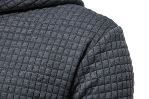 Macro detail of dark grey quilted waffle knit fabric and seam on men's hoodie
