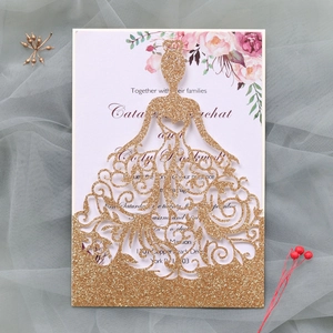 Détail d'invitation de mariage découpée au laser avec paillettes dorées et robe