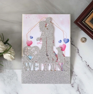 Detailed laser-cut wedding invitation with silver glitter finish and couple silhouette