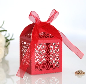Close-up of red laser-cut candy box with European floral patterns and ribbon