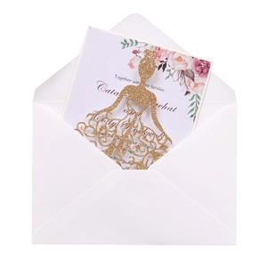 Détail de carte de mariage découpée au laser avec paillettes dorées et enveloppe blanche chic