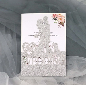 Macro detail of silver glitter laser-cut wedding invitation with Mr & Mrs silhouette