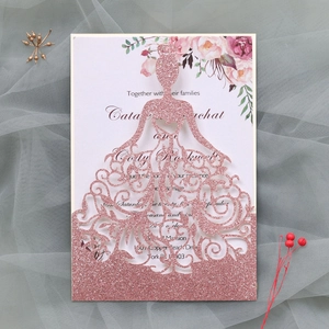 Détail de l'invitation de mariage rose pailletée avec découpe laser et motif floral
