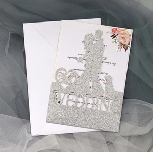Macro detail of silver glitter laser-cut wedding card featuring couple and dog silhouettes