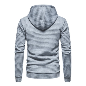 Detail view of the back of a light grey men's hoodie featuring a waffle texture fabric