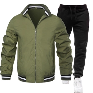 Details von olivgrüner Bomberjacke mit gestreiften Bündchen und schwarzer Jogginghose