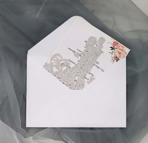 Macro detail of silver glitter laser-cut wedding card with couple silhouette