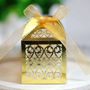 Detailed laser-cut pattern on gold reflective wedding favor box with organza ribbon