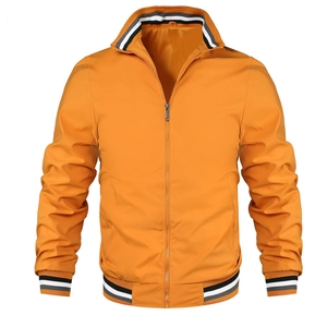 Detail of orange windproof jacket with black and white striped ribbed cuffs and collar