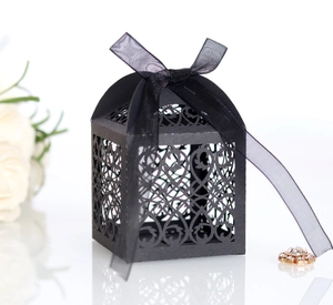 Detail of laser-cut European vine patterns on black gift box with silk ribbon bow