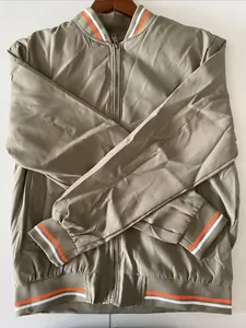 Detailed shot of beige bomber jacket featuring orange and white striped ribbed cuffs