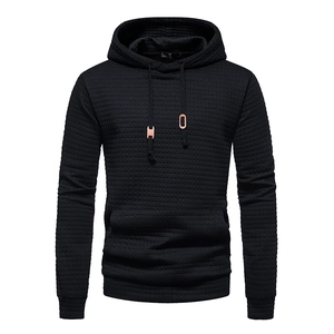Detail of men's black hoodie featuring 3D jacquard waffle texture and metal drawstring caps