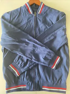 Detail of navy blue bomber jacket with red and white striped ribbed cuffs and collar