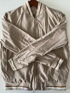 Close-up of light khaki bomber jacket with ribbed striped collar and zip closure