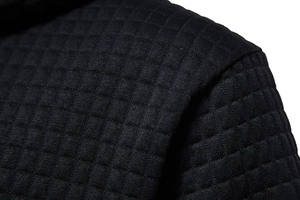 Macro view of men's black hoodie featuring a quilted waffle texture and thick knit fabric