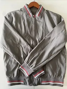 Close-up of grey bomber jacket with red and white striped ribbed cuffs and collar detail