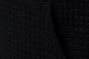 Detailed macro shot of premium black waffle weave fabric texture on a casual hoodie