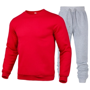 Detail of red crewneck sweatshirt and grey joggers set with ribbed cuffs and soft cotton texture