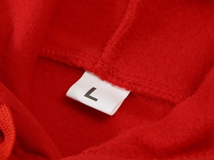 Detailed close-up of the interior fleece texture and size L label on a red hoodie