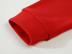 Detailed close-up of vibrant red ribbed elastic cuffs on heavy cotton hoodie sleeve