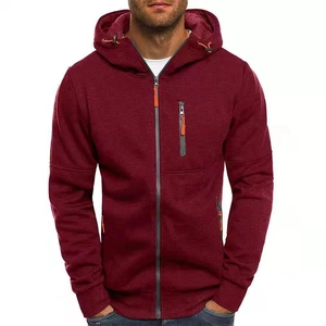 Détail d'un sweat à capuche bordeaux zippé avec texture tricotée et accents orange