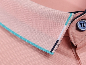 Détail macro du col polo en soie glacée rose avec des rayures tricolores distinctives