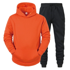 Detail van oranje hoodie met kangoeroezak en zwarte joggingbroek sportset voor heren