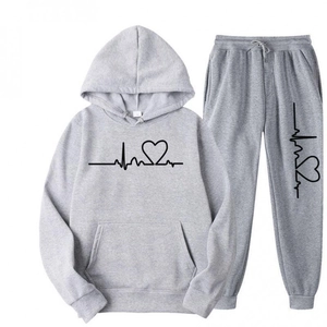 Detail of light gray hoodie and joggers set featuring black heart print and soft fabric