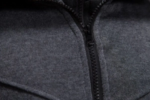 Detail of high-density knit fabric and durable black resin zipper on dark gray hoodie