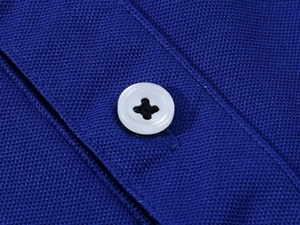 Macro detail of breathable navy pique fabric and white resin button on a men's polo shirt