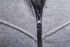 Detail shot of black plastic-steel zipper on light grey marl knit men's hoodie