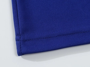 Macro shot of dark blue pique polo shirt hem featuring reinforced double stitching detail