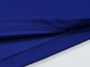 Macro shot of breathable dark blue honeycomb knit fabric with double stitching on polo shirt